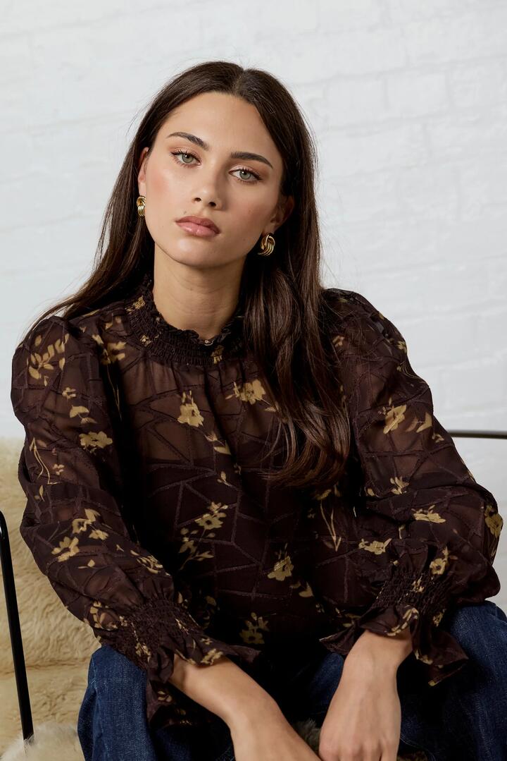 Image of a model wearing Tops. Product name - Affection Chocolate Butter Floral Shirred High Neck LS Top in Chocolate Butter Floral colour by brand - Among the Brave