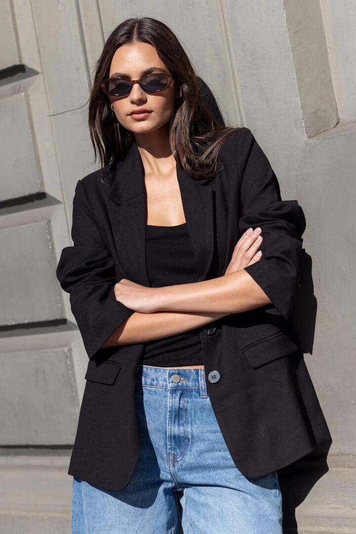 Image of a model wearing Outerwear. Product name - Diploma Black Two Button Vent Sleeve Blazer in Black colour by brand - Among the Brave