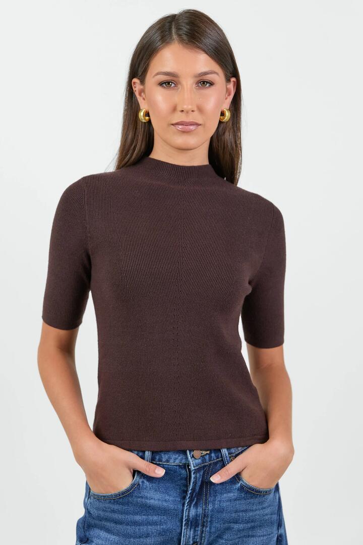Image of a model wearing Outerwear. Product name - Contour Chocolate Funnel Neck Short Sleeve Knitted Top in Chocolate colour by brand - Among the Brave