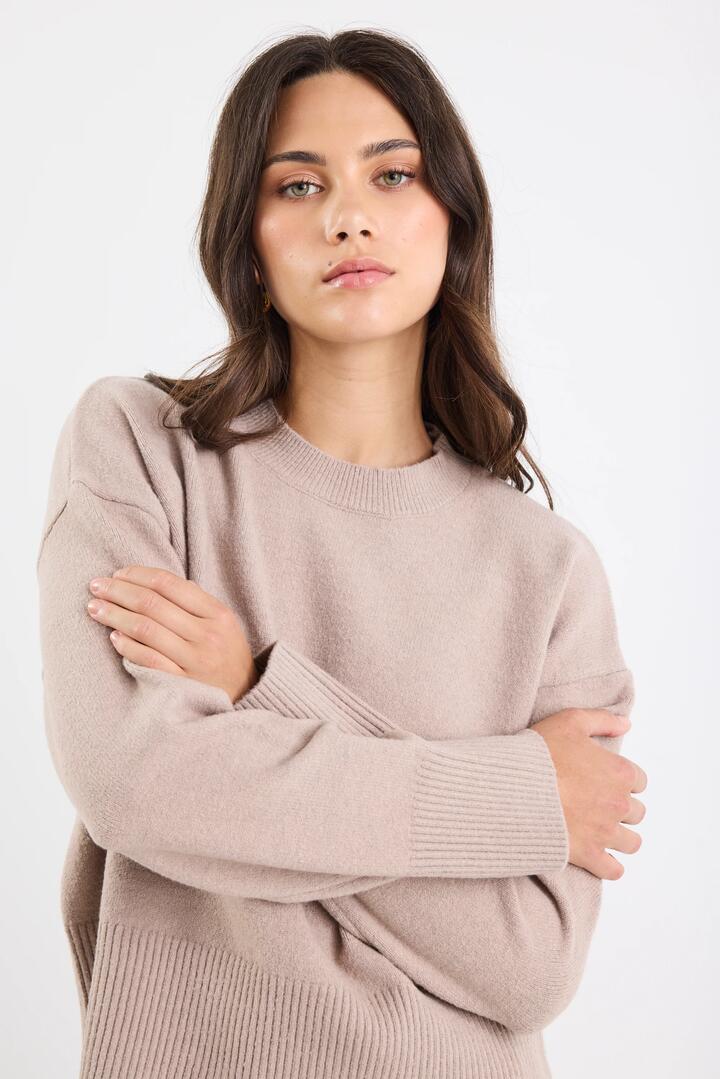Image of a model wearing Outerwear. Product name - Veracious Mushroom Crewneck Relaxed Jumper in Mushroom colour by brand - Among the Brave