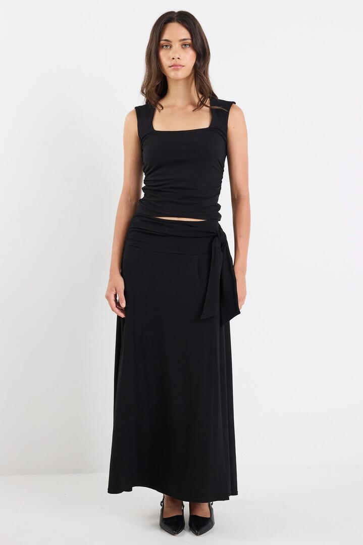 Image of a model wearing Skirts. Product name - Status Black Jersey Knot Front Maxi Skirt in Black colour by brand - Among the Brave