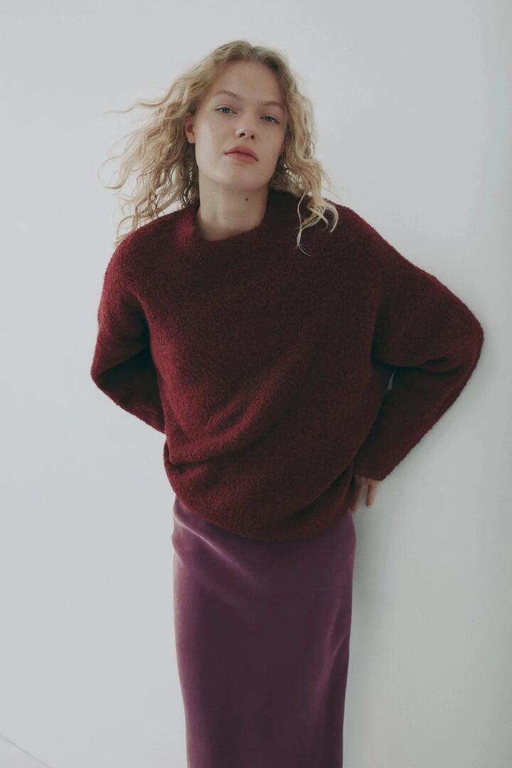 Image of a model wearing Outerwear. Product name - Elias Oxblood Textured Wool Blend Knit in Red colour by brand - Nude Lucy