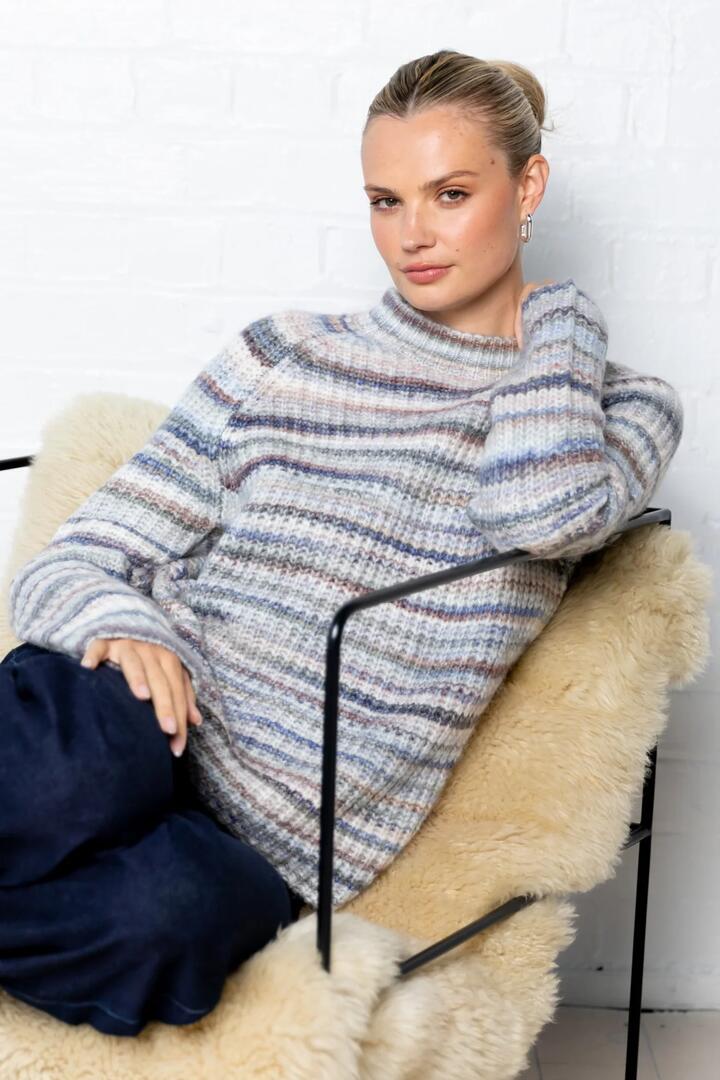 Image of a model wearing Outerwear. Product name - Orbit Blue Multi Funnel Neck Long Sleeve Space Dye Jumper in Blue Multi colour by brand - Among the Brave