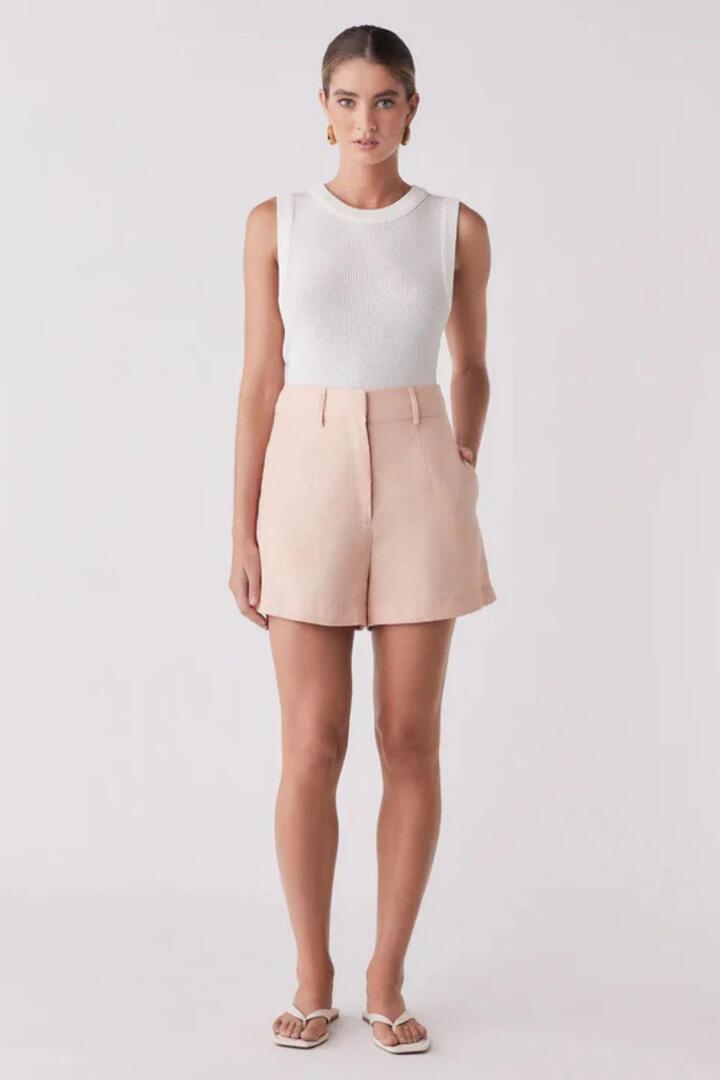 Image of a model wearing Shorts. Product name - Portsea Peach Linen Short in Orange colour by brand - Esmaee