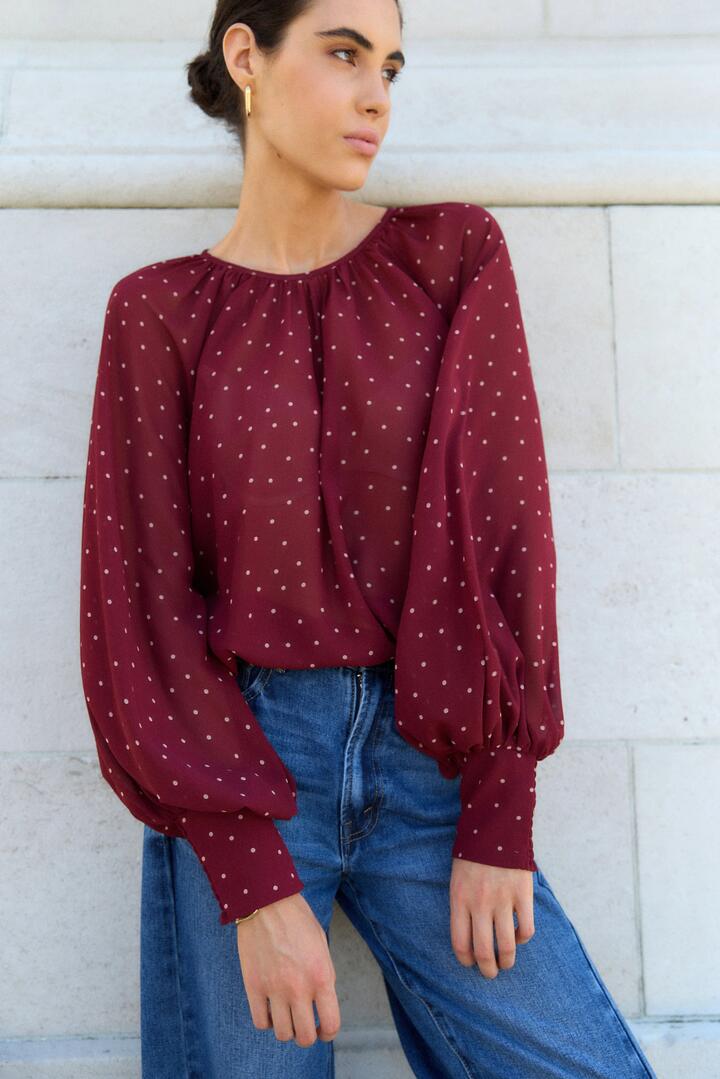 Image of a model wearing Tops. Product name - Cosmopolitan Burgundy Polka Dot Crew Neck Floaty LS Top in Burgundy Polka Dot colour by brand - Stories be Told