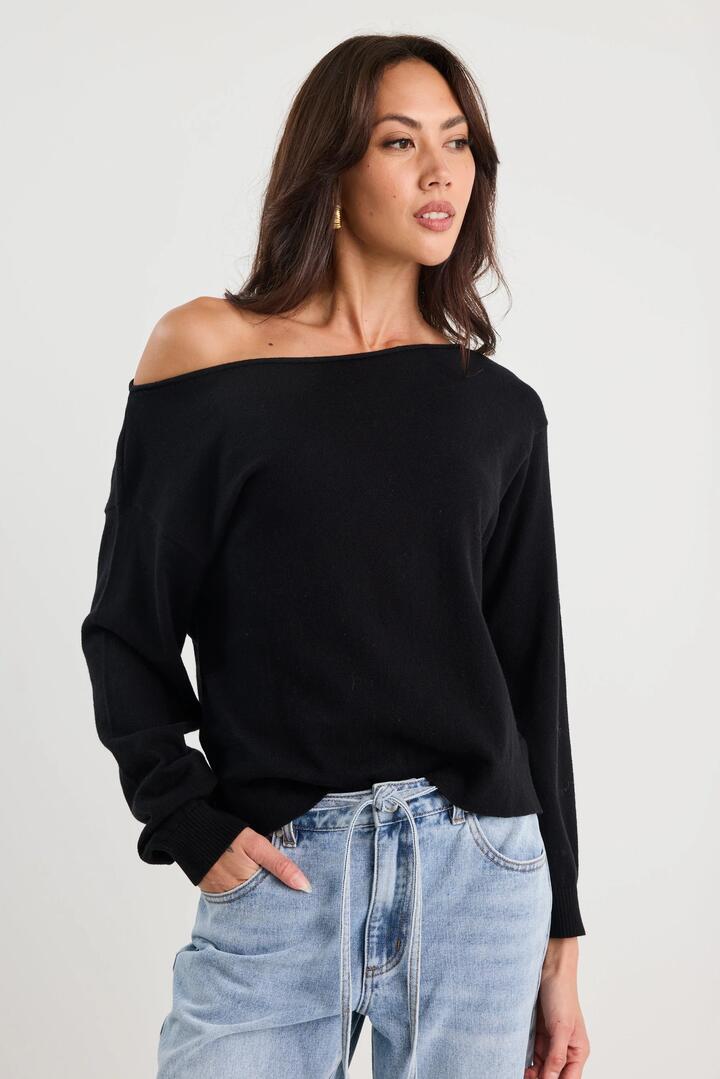 Image of a model wearing Outerwear. Product name - Reverb Black Off Shoulder Jumper in Black colour by brand - Among the Brave