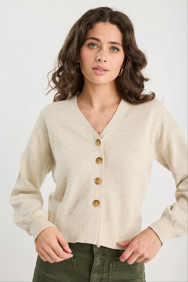 Image of a model wearing Outerwear. Product name - Purity Oat Marle V Neck Cardigan in Oat Marle colour by brand - Among the Brave