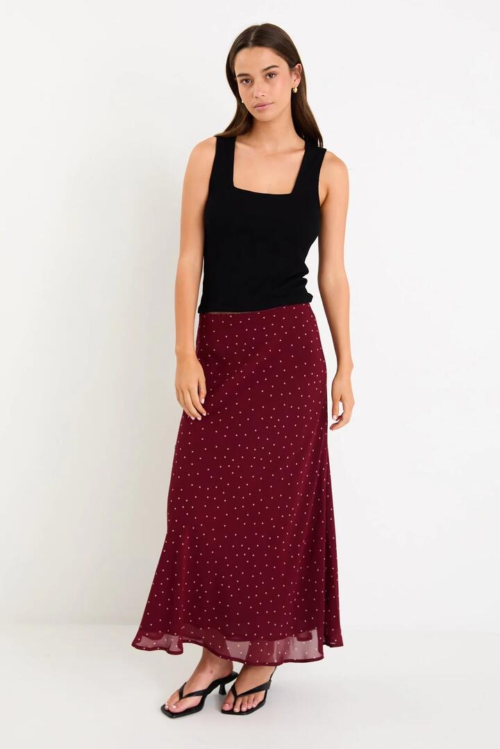 Image of a model wearing Skirts. Product name - Emporium Burgundy Polka Dot Georgette Bias Cut Midi Skirt in Burgundy Polka Dot colour by brand - Stories be Told