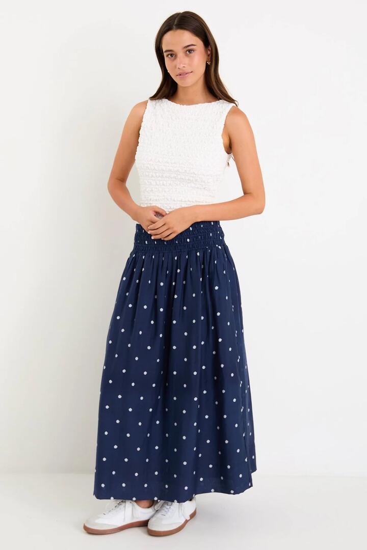 Image of a model wearing Skirts. Product name - Wanderlust Navy Polka Dot Shirred Waist Maxi Skirt in Navy Polka Dot colour by brand - Stories be Told
