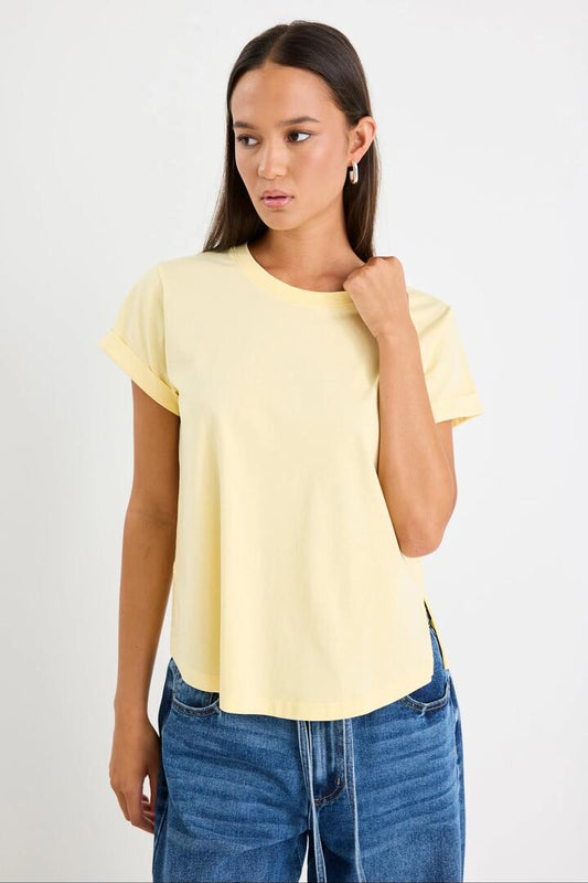 Image of a model wearing Tops. Product name - Editor Butter Crew Neck Short Sleeved Tee in Butter colour by brand - Among the Brave