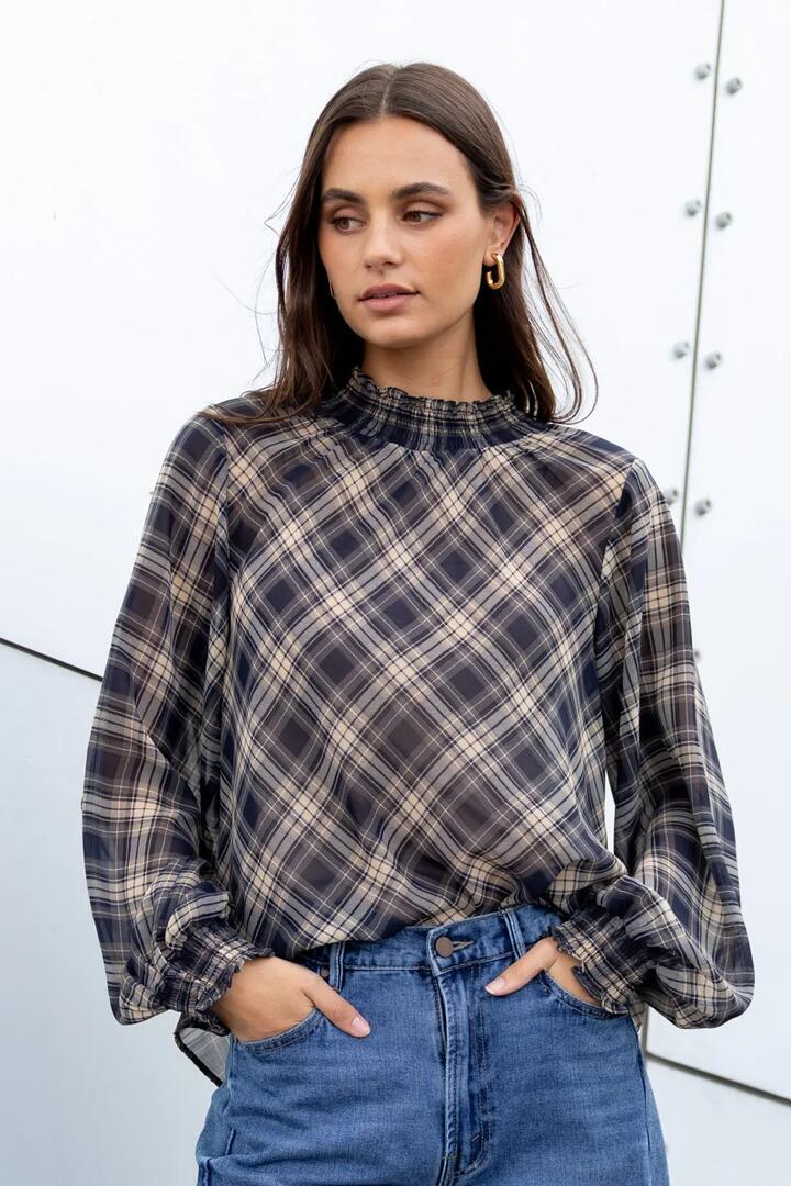 Image of a model wearing Tops. Product name - Embrace Black Check Chiffon Shirred Neck LS Top in Black Check Chiffon colour by brand - Among the Brave
