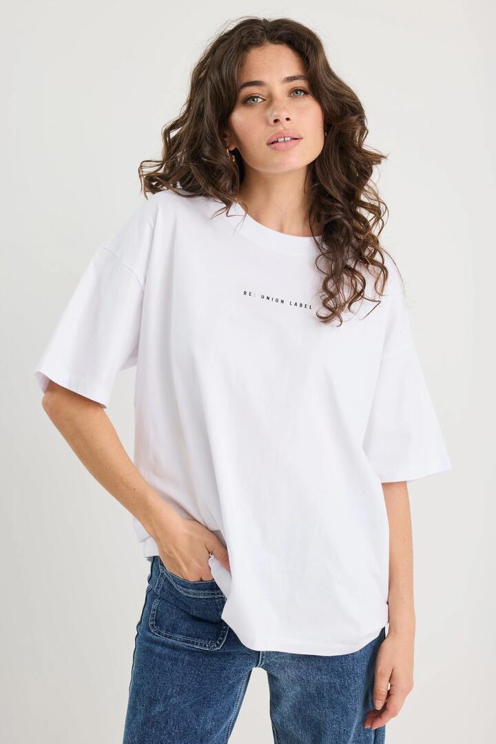 Image of a model wearing Tops. Product name - Novel White Cotton Re:Union Oversized Tee in White colour by brand - RE:UNION Label