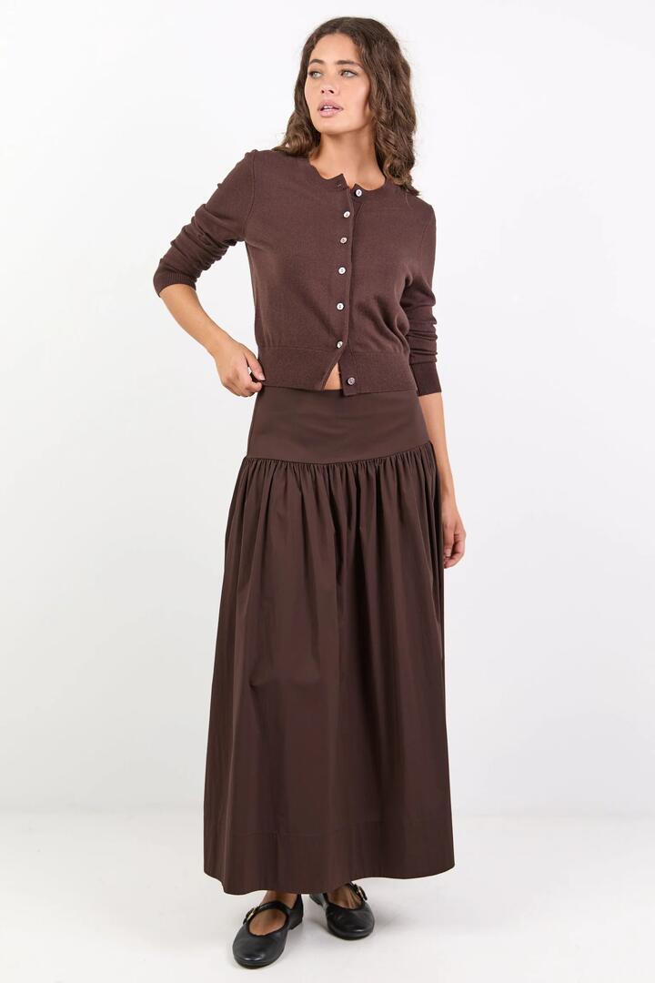 Image of a model wearing Skirts. Product name - Affinity Chocolate Cotton Blend Shirred Back Tiered Maxi Skirt in Chocolate colour by brand - Ivy + Jack