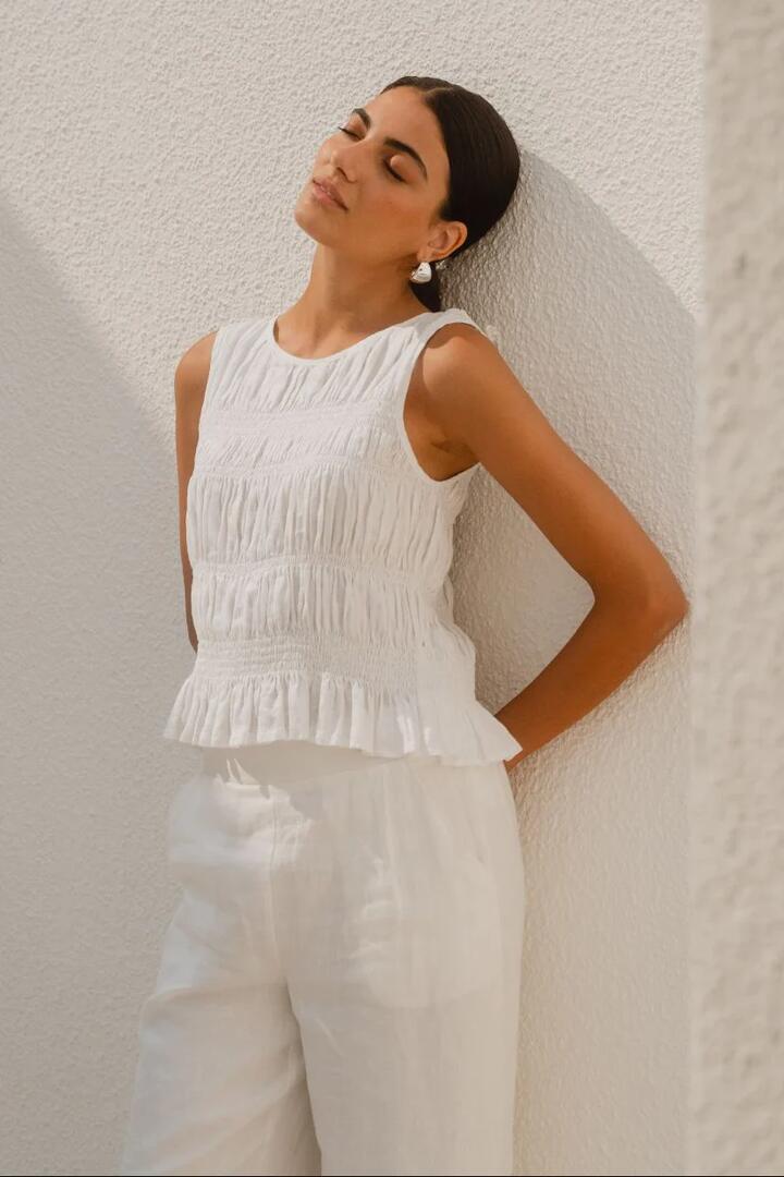 Image of a model wearing Tops. Product name - Impulsive Ivory Linen Shirred Sleeveless Top in Ivory Linen colour by brand - Among the Brave