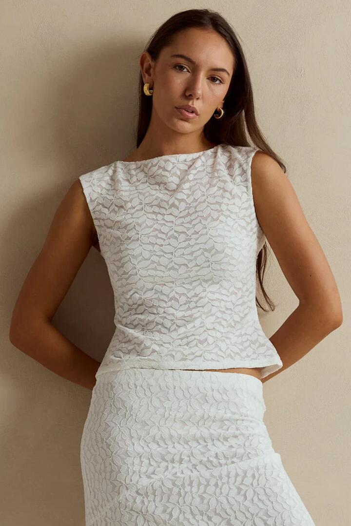 Image of a model wearing Tops. Product name - Breathless Ivory Lace Sleeveless Top in Ivory Lace colour by brand - Stories be Told