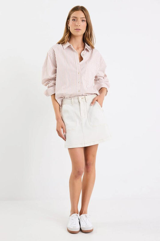 Image of a model wearing Skirts. Product name - Orchard Ecru Denim Pocket Front Mini Skirt in Ecru colour by brand - Ivy + Jack