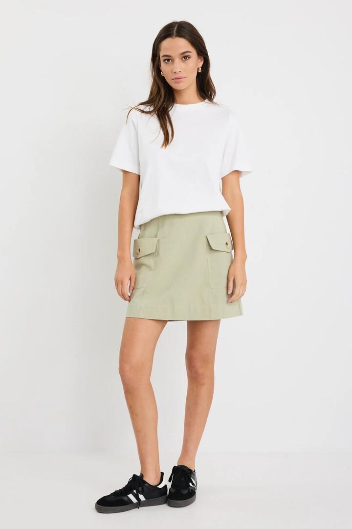 Image of a model wearing Skirts. Product name - Savanna Sage Canvas Pocket Mini Skirt in Sage colour by brand - Among the Brave