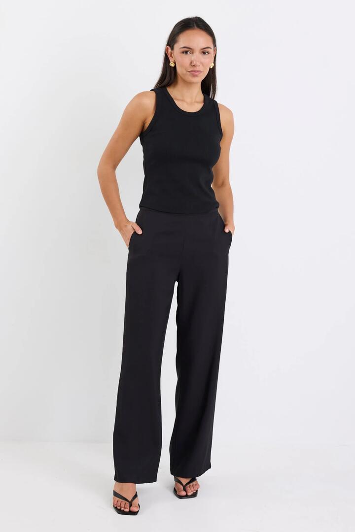 Image of a model wearing Pants. Product name - Dancer Black Wide Leg Zip Back Pants in Black colour by brand - Ivy + Jack