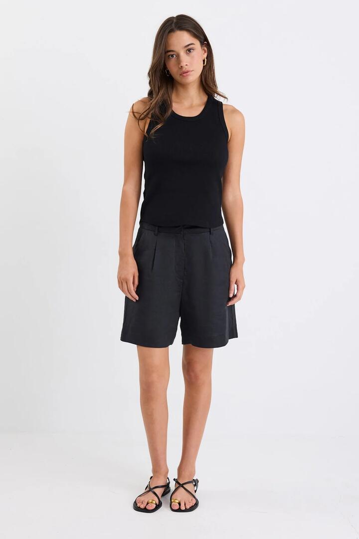 Image of a model wearing Shorts. Product name - Literal Black Linen Pleat Front Shorts in Black Linen colour by brand - Stories be Told