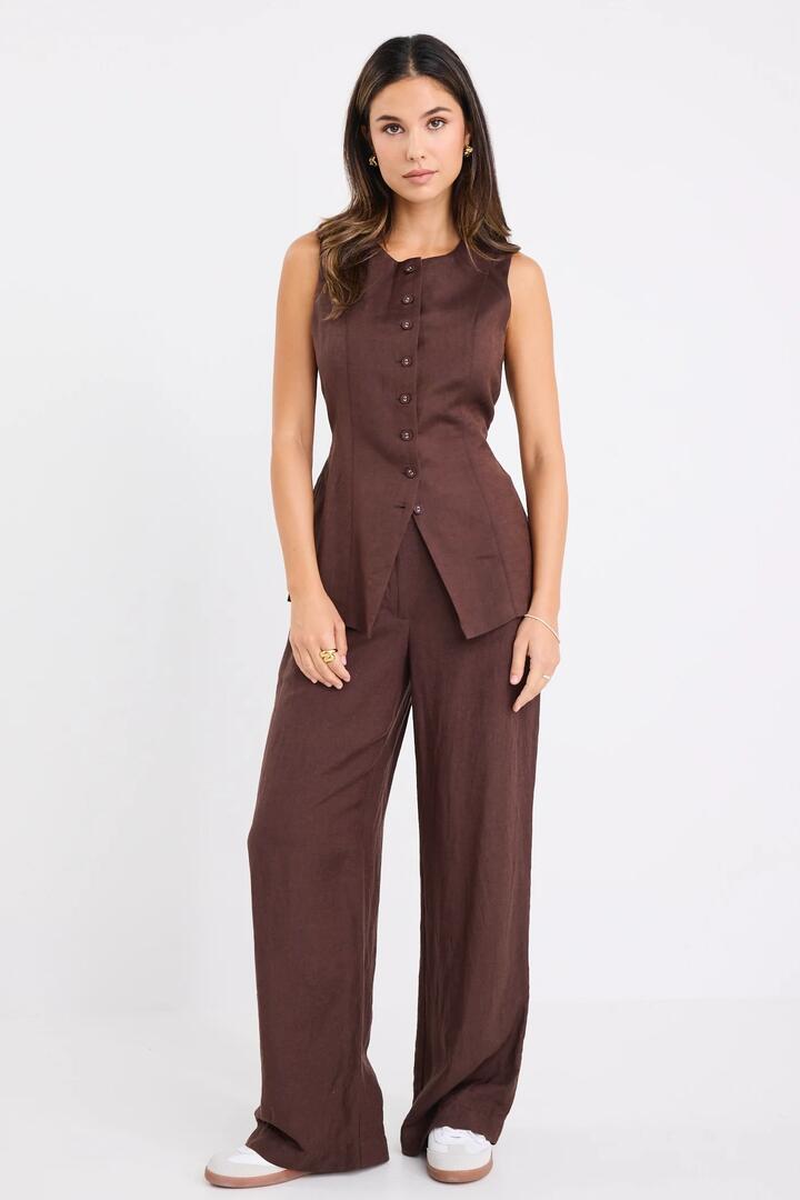 Image of a model wearing Pants. Product name - Shelter Chocolate Linen Viscose Flat Front Wide Pants in Chocolate colour by brand - RE:UNION Label
