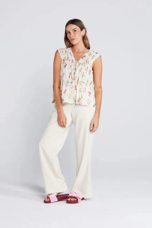 Image of a model wearing Tops. Product name - Belle Summer Haven Cream Floral Reversible Sleeveless Tie Top in Cream colour by brand - Thing Thing