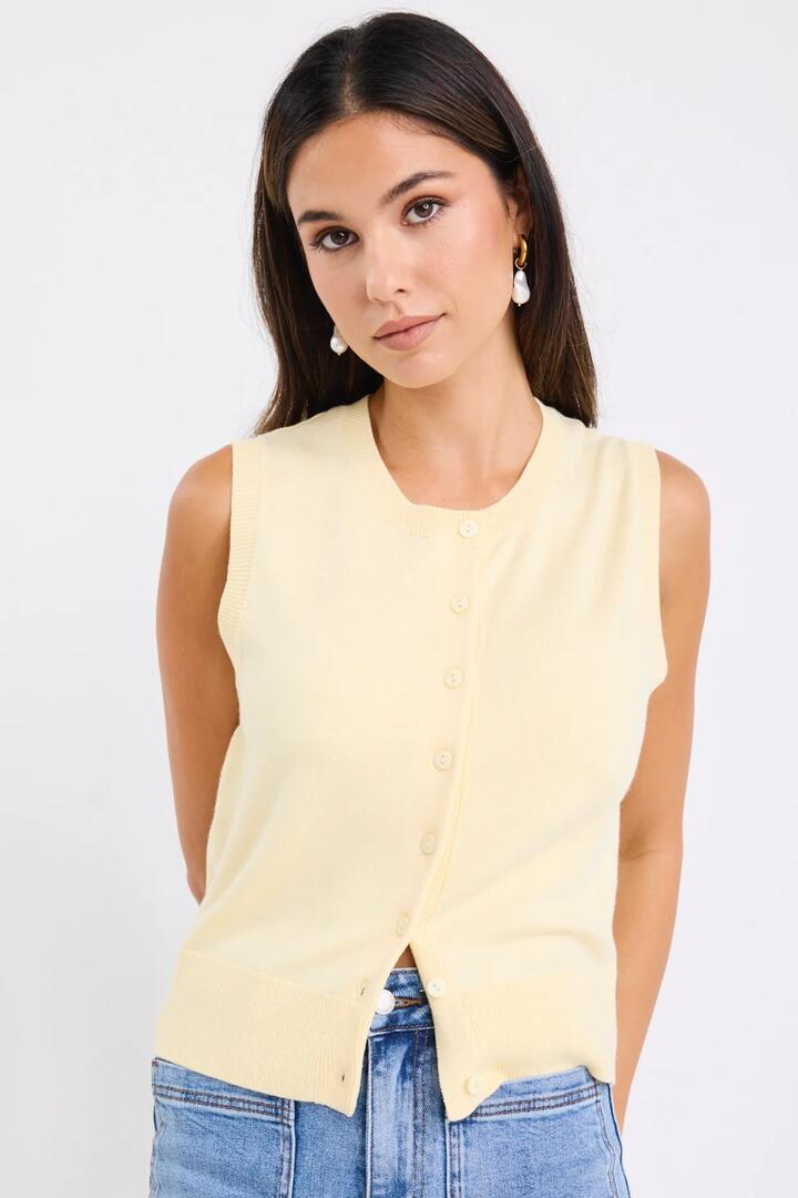 Image of a model wearing Outerwear. Product name - Alleyway Butter Lightweight Soft Knit Crewneck Vest Top in Butter colour by brand - Among the Brave