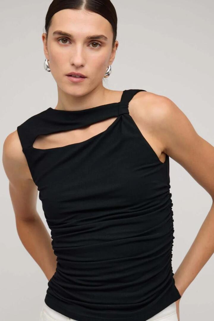 Image of a model wearing Tops. Product name - Mira Black Cutout Sleeveless Top in Black colour by brand - Staple The Label