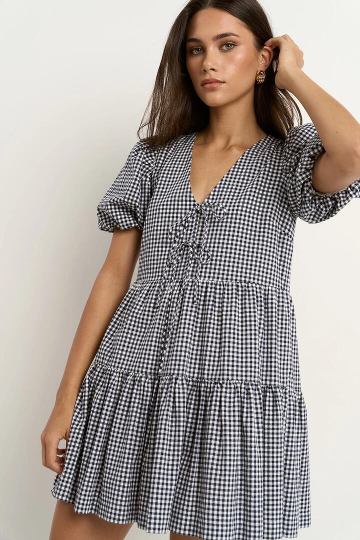 Image of Dresses. Product name - Roam Navy Gingham Puff Sleeve Tie Front Mini Dress in Navy Gingham colour by brand - Ivy + Jack