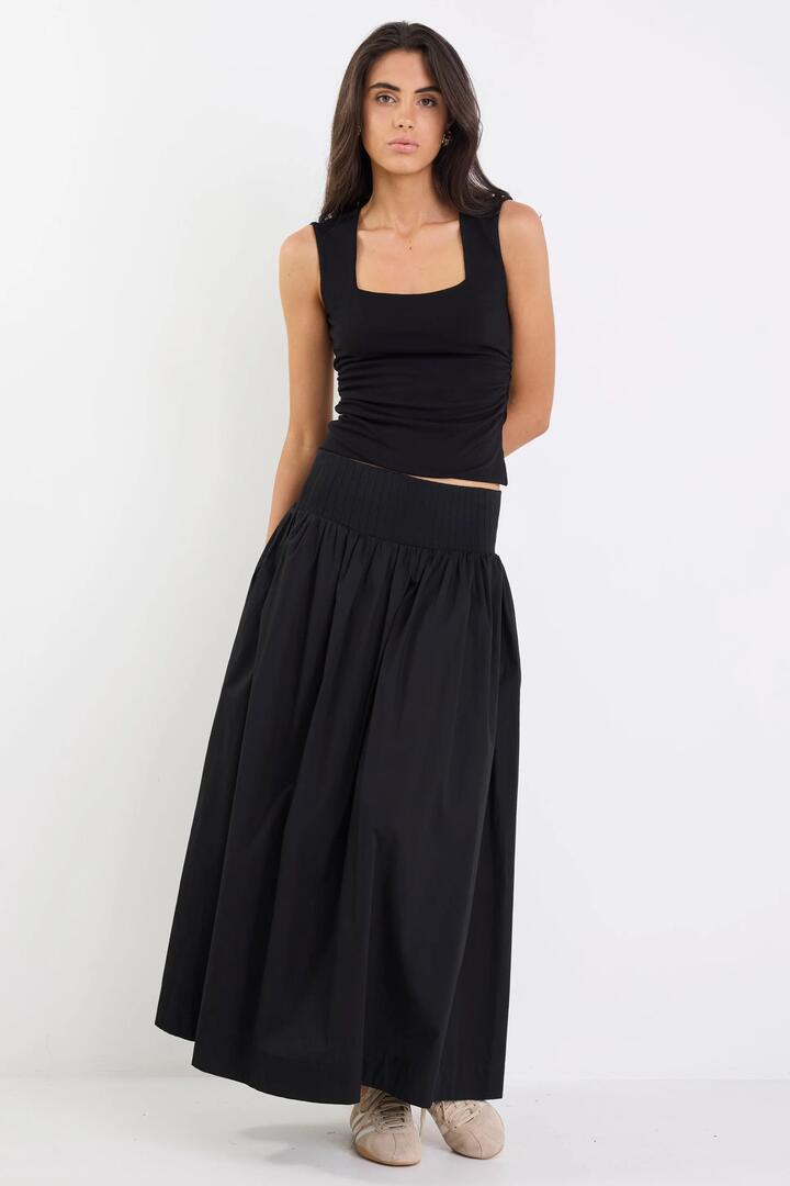 Image of a model wearing Skirts. Product name - Tallow Black Poplin Rib Waist Maxi Skirt in Black colour by brand - Ivy + Jack