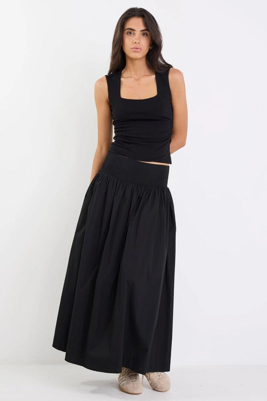 Image of a model wearing Skirts. Product name - Tallow Black Poplin Rib Waist Maxi Skirt in Black colour by brand - Ivy + Jack