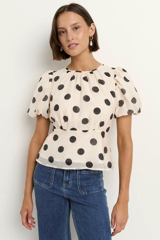 Image of a model wearing Tops. Product name - Finali Cream Black Polka Dot Puff Short Sleeve Top in Cream Black Polka Dot colour by brand - Stories be Told