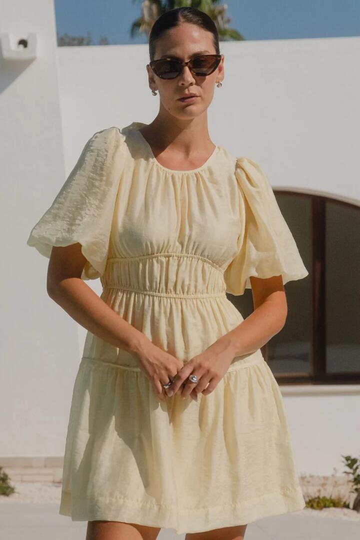 Image of Dresses. Product name - Girlfriend Butter Puff Sleeve Tie Back Mini Dress in Butter colour by brand - Georgia Zoe