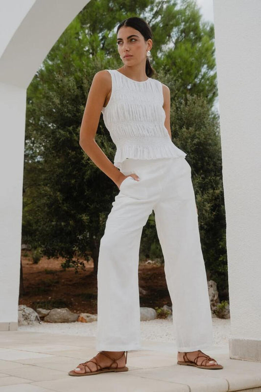 Image of a model wearing Pants. Product name - Guardian White Linen Viscose Pleat Front Wide Leg Pant in White colour by brand - Among the Brave