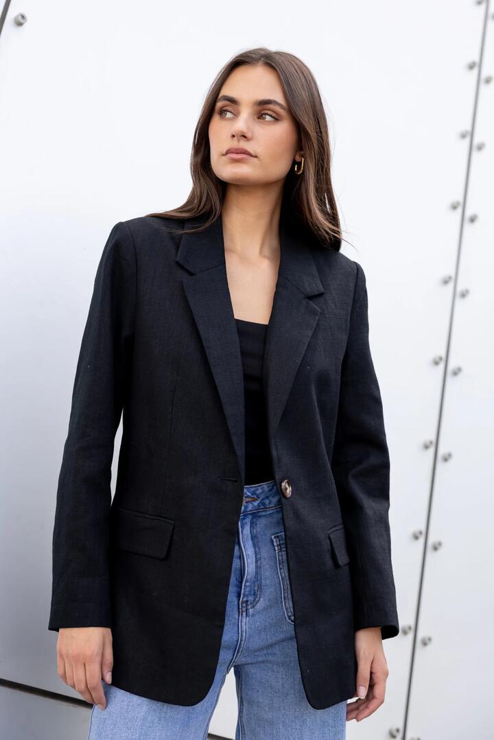 Image of a model wearing Outerwear. Product name - Dock Black Ramie Rolled Sleeve Blazer in Black colour by brand - Ivy + Jack