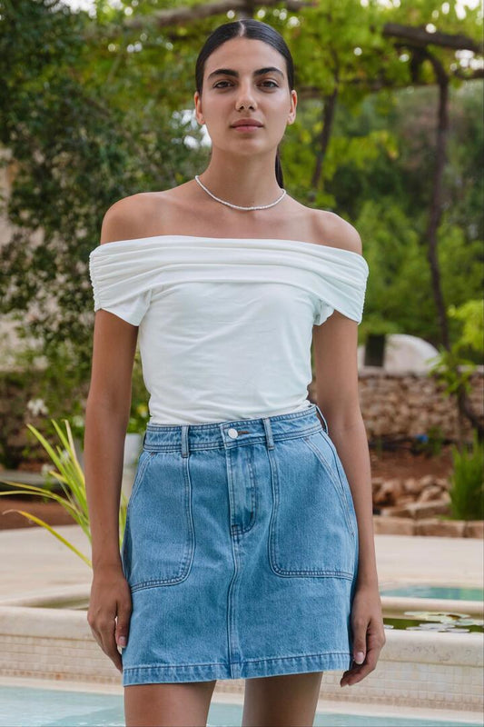 Image of a model wearing Skirts. Product name - Orchard Mid Blue Pocket Front Denim Mini Skirt in Mid Blue colour by brand - Ivy + Jack