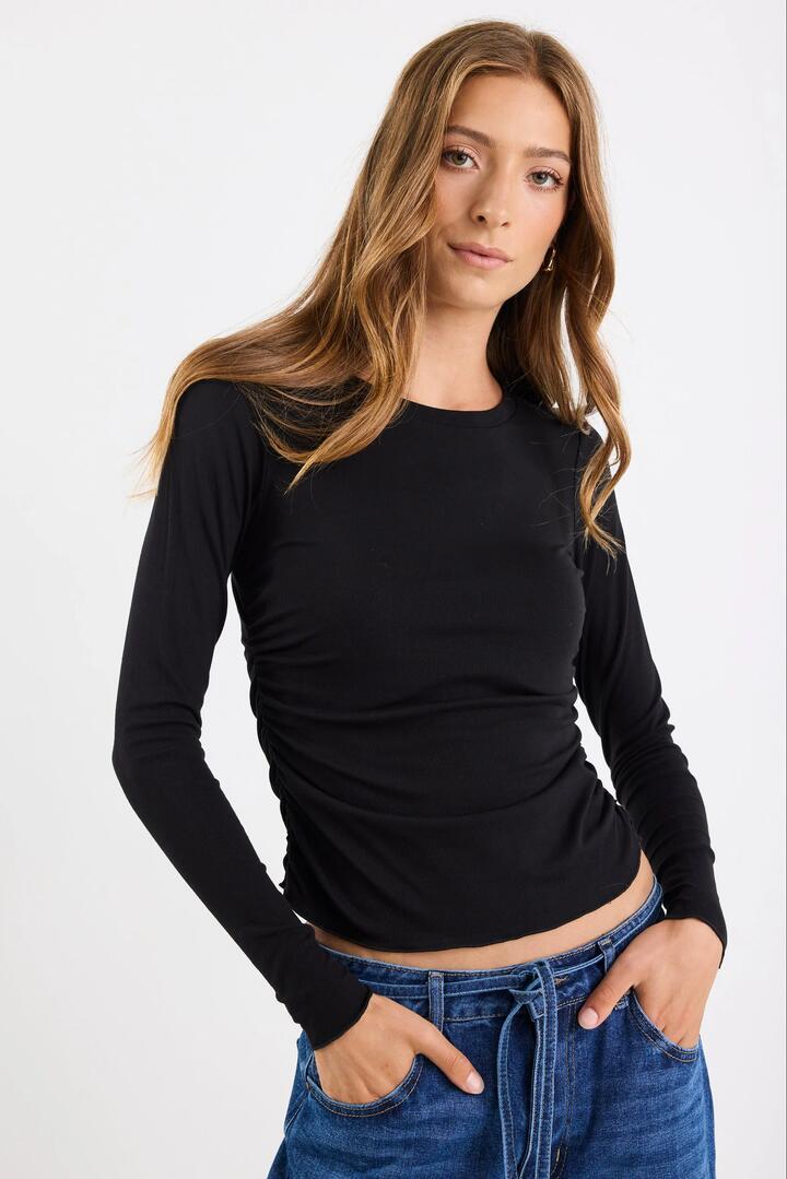Image of a model wearing Tops. Product name - Muster Black Stretch Rouched Side LS Crew Top in Black Stretch colour by brand - Among the Brave