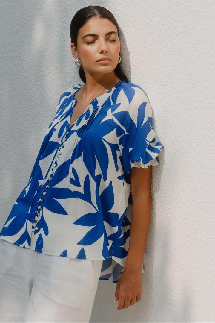 Image of a model wearing Tops. Product name - Antic Bright Blue Abstract Button Front SS Top in Bright Blue Abstract colour by brand - Among the Brave