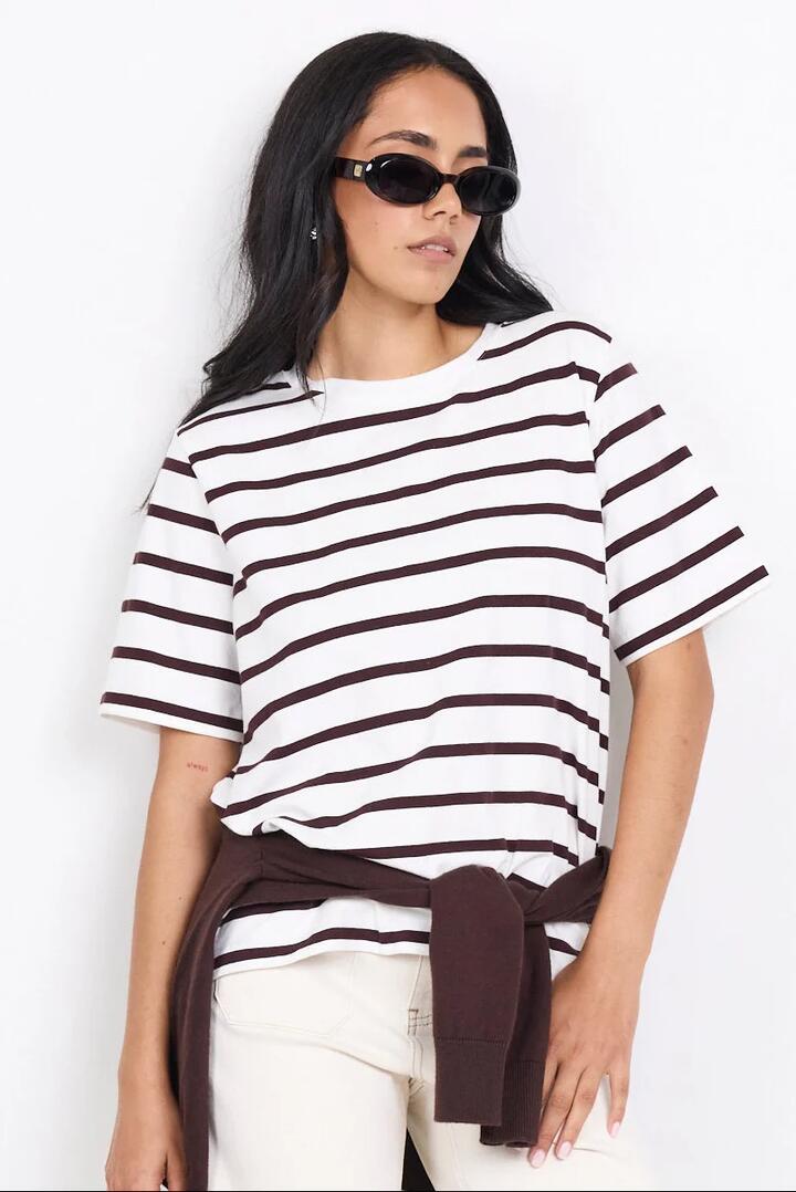 Image of a model wearing Tops. Product name - Binding Chocolate White Stripe Boxy Fit Tee in Chocolate White Stripe colour by brand - RE:UNION Label