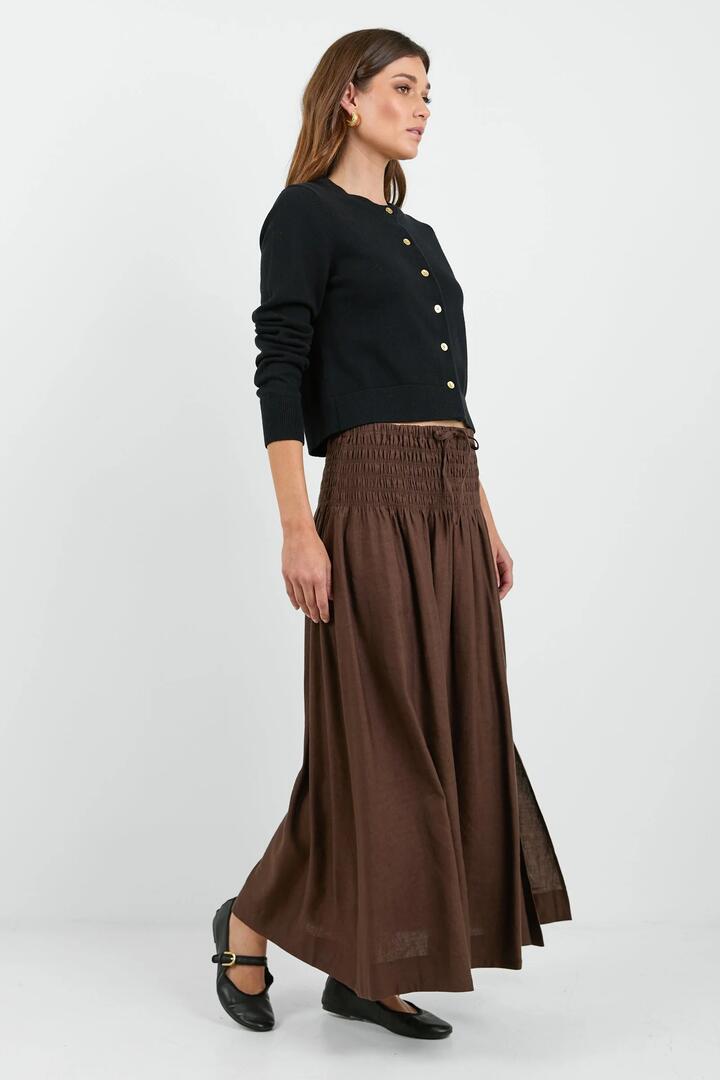 Image of a model wearing Skirts. Product name - Byron Chocolate Linen Blend Shirred Waist Maxi Skirt in Chocolate colour by brand - RE:UNION Label