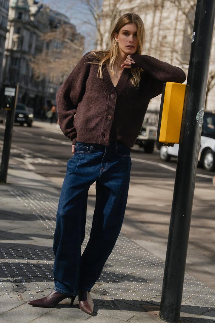 Image of a model wearing Outerwear. Product name - Essence Chocolate V Neck Rib Knit Cardigan in Chocolate colour by brand - Stories be Told