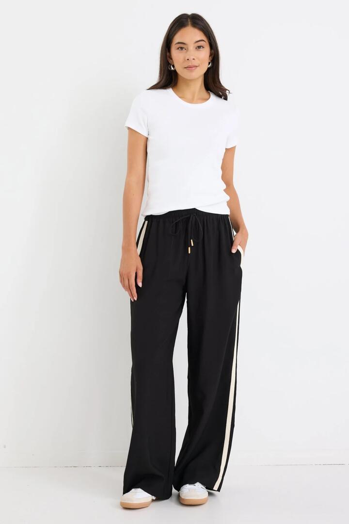 Image of a model wearing Pants. Product name - Townie Black Matte Stripe Side Tape Wide Leg Pants in Black Matte colour by brand - Stories be Told