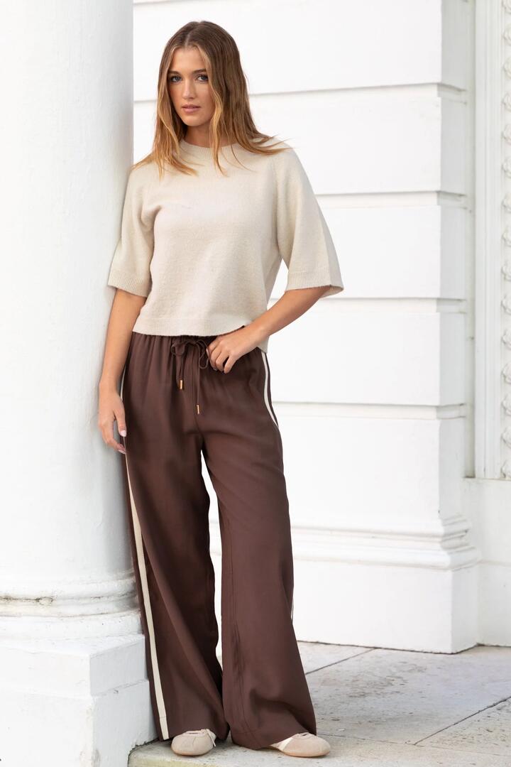 Image of a model wearing Pants. Product name - Townie Chocolate Stripe Side Tape Wide Leg Pants in Chocolate colour by brand - Stories be Told