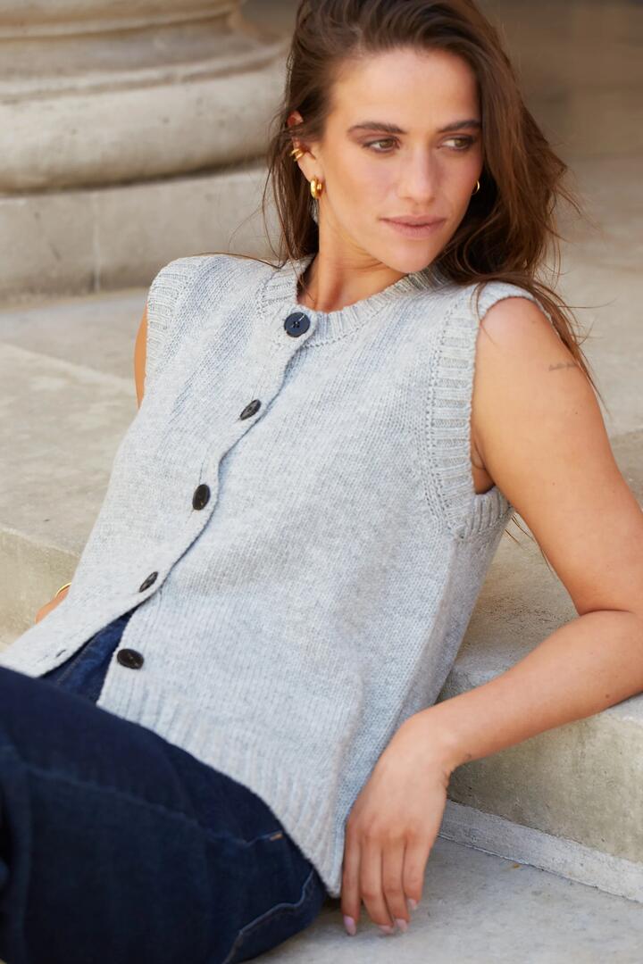 Image of a model wearing Outerwear. Product name - Stamp Grey Marle Crewneck Knit Vest Top in Grey Marle colour by brand - Stories be Told