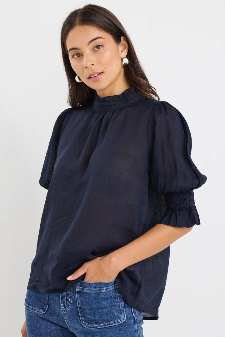 Image of a model wearing Tops. Product name - Verse Navy Sheer High Neck Short Sleeve Top in Navy colour by brand - By Rosa.