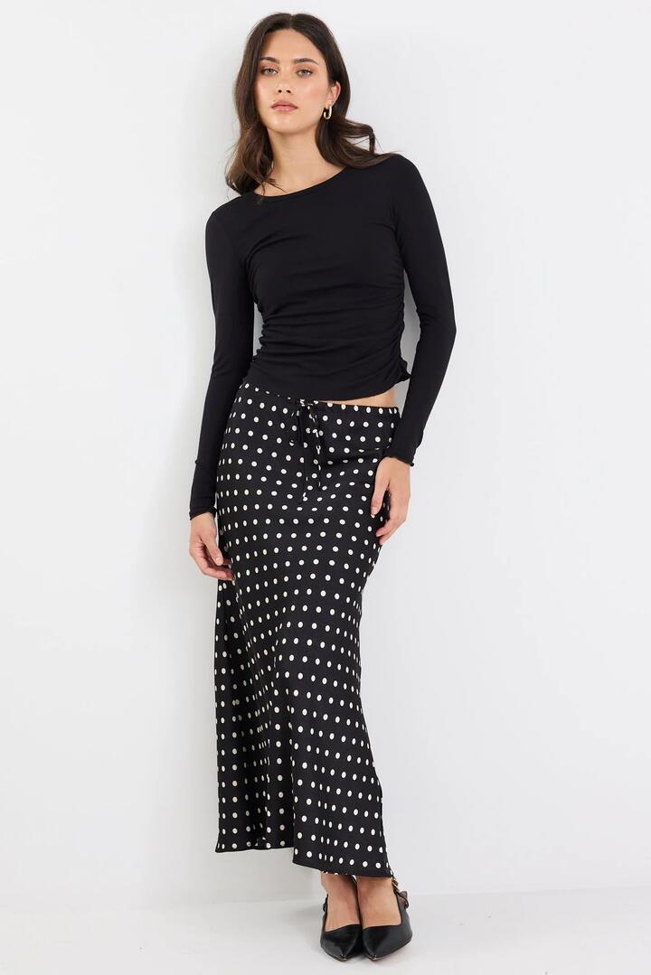 Image of a model wearing Skirts. Product name - Rarity Black White Polka Dot Satin Tie Waist Bias Maxi Skirt in Black White Spot colour by brand - Stories be Told
