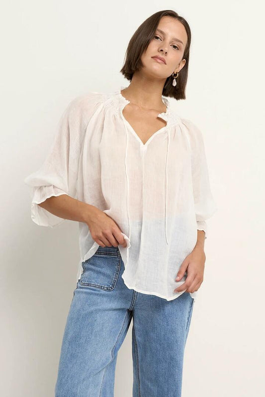 Image of a model wearing Tops. Product name - Expedition Ivory Ramie Shirred Neck Short Sleeve Top in Ivory Ramie colour by brand - Among the Brave