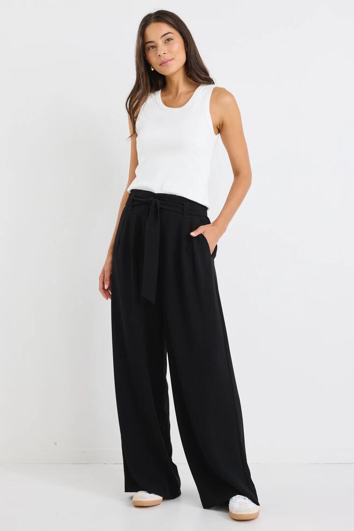 Image of a model wearing Pants. Product name - Sydney Black Crepe Wide Leg Tie Belt Pant in Black colour by brand - Stories be Told
