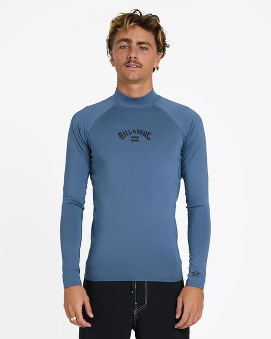 Image of a model wearing Tops. Product name - Billabong Mens All Day Arch Pf Long Sleeve Rash Vest Steel Blue in Steel Blue colour by brand - Billabong