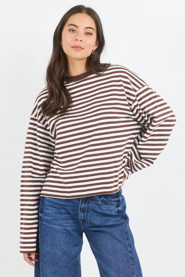 Image of a model wearing Tops. Product name - Unite Chocolate White Stripe Long Sleeve Contrast Binding Boxy Tee in Chocolate White Stripe colour by brand - Stories be Told