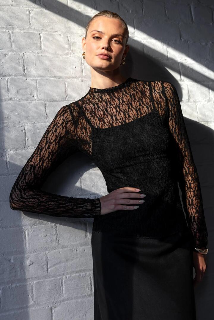 Image of a model wearing Tops. Product name - Giving Black Lace Long Sleeve Top in Black Lace colour by brand - Among the Brave